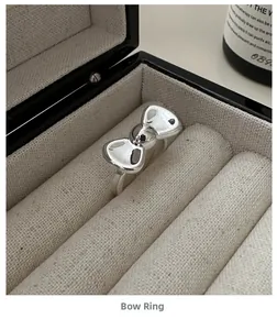 Detailed view of an S925 sterling silver bow ring inside a beige jewelry gift box