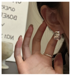 Gros plan sur des créoles en argent sterling S925 avec finition texturée en métal liquide