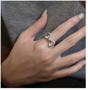 Detail shot of a minimalist silver bow ring showing the polished metal finish and bow knot
