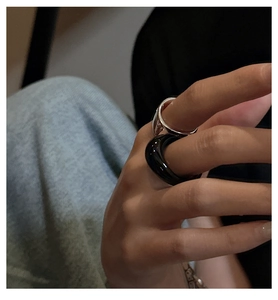 Close-up of minimalist stacked rings in polished silver metal and glossy black finish