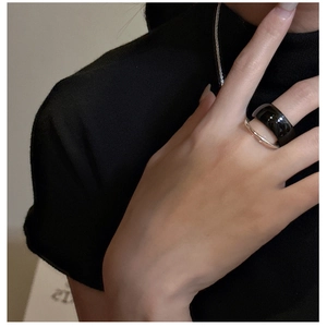 Close-up of minimalist double-layer black onyx and silver ring on a model's finger