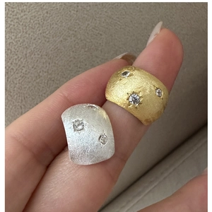Macro detail of brushed silver and gold rings featuring star-set round zircon stones