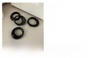 Detail of four chunky minimalist black rings made of S925 sterling silver in packaging