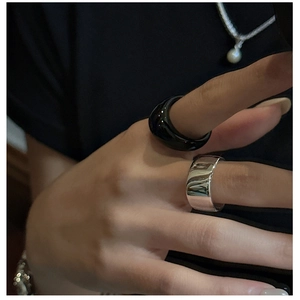 Detailed close-up of a stackable black resin band and silver metal ring on finger