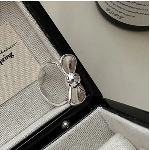 Macro shot of silver bow ring in gift box with polished finish and adjustable band