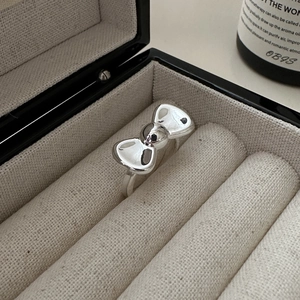 Minimalist S925 sterling silver bow ring with polished mirror finish in a jewelry box