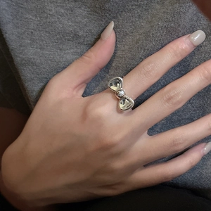 Minimalist S925 sterling silver bow ring with polished mirror finish on model hand