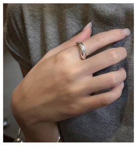 Macro detail of minimalist S925 sterling silver wavy ring with polished fluid metal texture