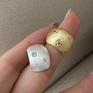 Textured wide silver and gold band rings featuring star-set sparkling zircons