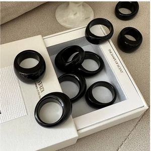 Close-up of sleek black resin rings with polished finish displayed in a minimalist box