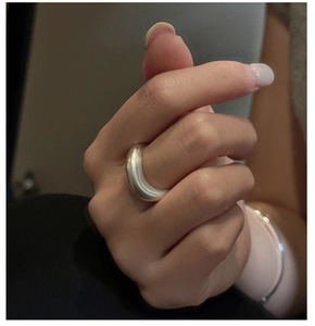 Detail of matte S925 sterling silver ring and slim wave textured bracelet on model