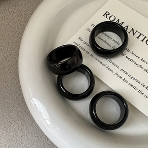 Polished black onyx rings in a minimalist set displayed on a white ceramic dish