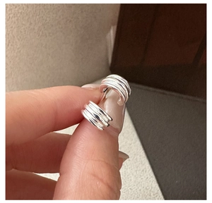 Detailed view of S925 sterling silver triple-layered textured earrings held by hand