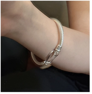 Macro detail of S925 silver horseshoe bracelet featuring intricate twisted rope texture