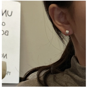 Macro detail of silver S925 earrings featuring a multi-layer parallel line C-shape design