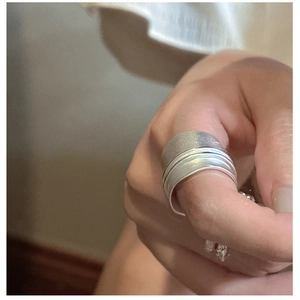 Close-up of stacked S925 sterling silver rings with matte finish on a female model hand