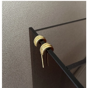 Close-up of S925 sterling silver triple-layered textured hoop earrings with gold plating