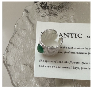Detailed macro shot of vintage S925 silver ring with green agate and woven texture
