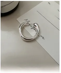 Detail eines unregelmäßigen silbernen Minimalist-Rings auf hellem Hintergrund für modernen Stil