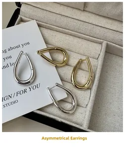 Close-up of gold and silver irregular water drop hoop earrings in a jewelry box