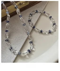 Gros plan d'un ensemble en argent S925 avec cristaux clairs et pierres bleues sur de la porcelaine