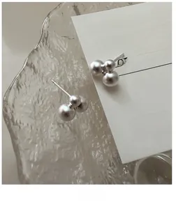 Macro shot of S925 sterling silver ball earrings featuring a matte frosted texture finish