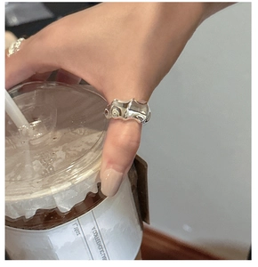 Detail of S925 silver irregular lava ring worn by a model holding a coffee cup