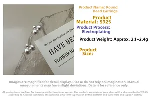 Macro detail of matte S925 sterling silver ball earrings showing weights of 2.1g-2.4g