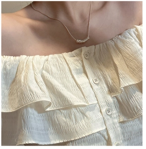 Close-up of S925 silver coiled spring pendant on a minimalist necklace for women