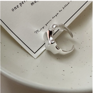 Detailed close-up of S925 sterling silver ring with irregular wavy texture on ceramic bowl