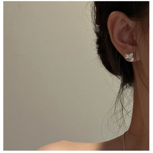 Close-up of S925 sterling silver triple pearl cluster stud earrings on female ear