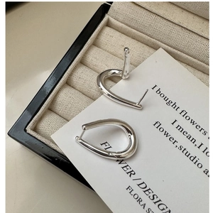 Macro detail of S925 sterling silver earrings with irregular twisted teardrop design