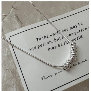 Detail of S925 sterling silver snake chain necklace with polished spring-style ring pendants