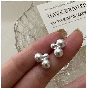 Macro view of matte S925 sterling silver earrings with three clustered beads