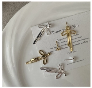 Detailed view of S925 sterling silver bow earrings with hallmark engraving and texture