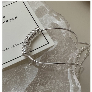 Close-up of S925 sterling silver snake chain with modern spiral spring pendant detail