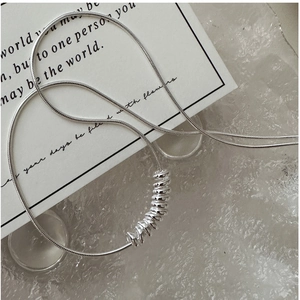 Macro shot of S925 sterling silver snake chain necklace with textured metal rings detail