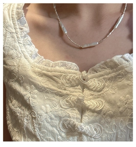 Detail of s925 silver beaded necklace with white baroque pearls on model collarbone