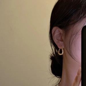 Elegant gold drop earrings in S925 sterling silver worn by a model in a warm setting