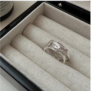 Macro shot of an irregular wavy S925 sterling silver ring resting in a premium jewelry box