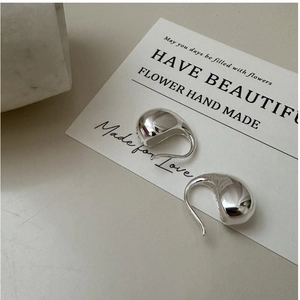 Macro shot of S925 sterling silver teardrop earrings with a polished mirror finish
