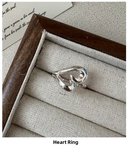 Detailed macro view of S925 sterling silver heart ring in a wooden jewelry box