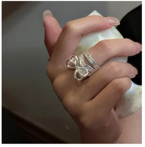 Detailed view of S925 sterling silver bow ring with textured band on model hand