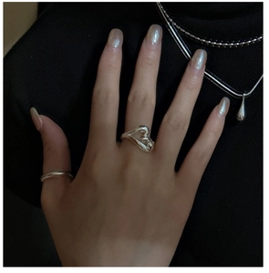 Detail of S925 silver fluid heart and minimalist ring set shown on a hand
