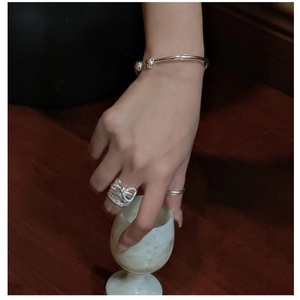 Detailed view of an S925 sterling silver bow ring with textured finish on model hand