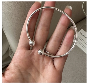 Detail eines polierten S925 Sterling Silber Armreifs mit großem Kugel-Enden-Design