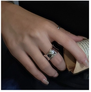 Gros plan sur une bague large minimaliste en argent S925 avec finition miroir polie