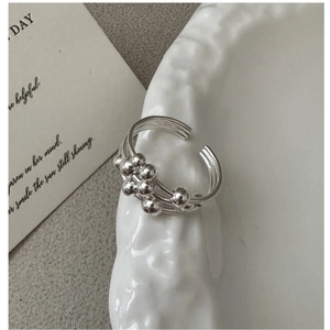 Close-up of S925 sterling silver multilayer ring with beads on vintage white plate
