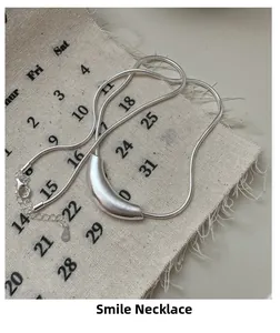 Detail of S925 sterling silver smile necklace featuring a matte curved snake chain design