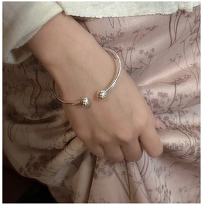 Nahaufnahme des S925 Sterling Silber Armreifs mit polierten Perlenenden im Minimal-Stil
